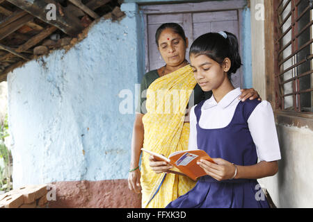 Mutter stand neben Schule gehen Tochter Lesebuch, Maharashtra, Indien Herr #703Y, 703Z Stockfoto