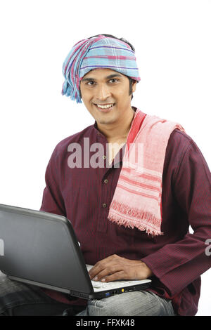 Reichen indischen Bauern gebunden Gamcha am Kopf, die anderen auf Schulter mit Laptop Herr #743A gehalten Stockfoto