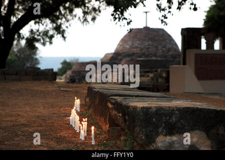 Kerzen beleuchtet von Anhängern Abend mit kleinen Stupa im Hintergrund bei Sanchi, Bhopal, Madhya Pradesh, Indien Stockfoto