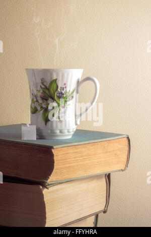 Tasse Tee stehen auf Stapel alter Bücher Stockfoto