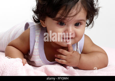 Fröhliche Babymädchen im Kleid hinlegen auf rosa Tuch Herr #765 Stockfoto