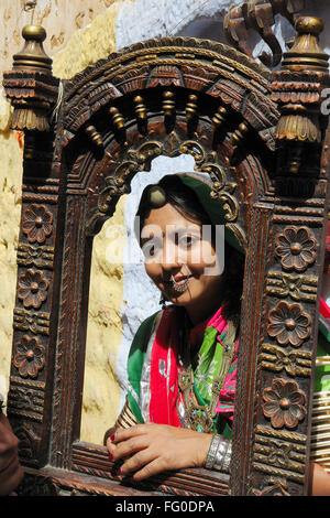 Lady in bunten Trachten, die durch hölzerne Jharoka; Jaisalmer; Rajasthan; Indien Herr # 772 Stockfoto