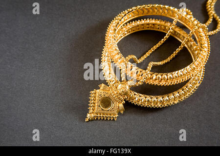 Goldene Halskette mit Medaillon und goldenen Armreifen Stockfoto