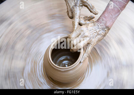 Töpferei , Töpfer Künstler schlammigen Hände machen Tontopf geben Form auf Spinnrad , Dilwara , Udaipur , Rajasthan , Indien , Asien Stockfoto