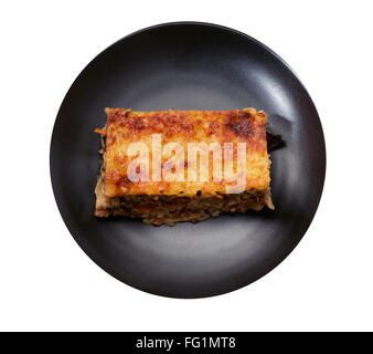 Isolierte Stück Lasagne auf der schwarzen Platte Stockfoto