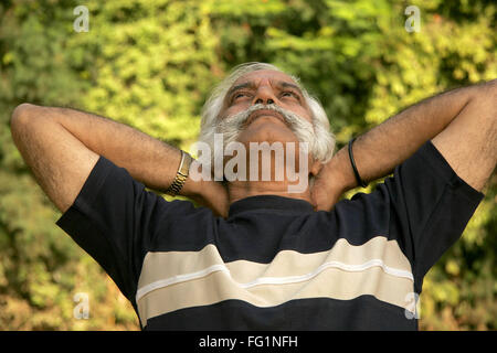 Älterer Herr im dunklen blau-T-Shirt über sechzig Jahre alt Rast- und denken mit einem Blick in den Himmel im Park Herr #686A Stockfoto