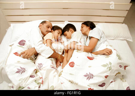 Südasiatische indischen ideale Familie kuscheln miteinander mit eingeschlafen auf Bett Herr #686E, 191, 686D, 189 Stockfoto