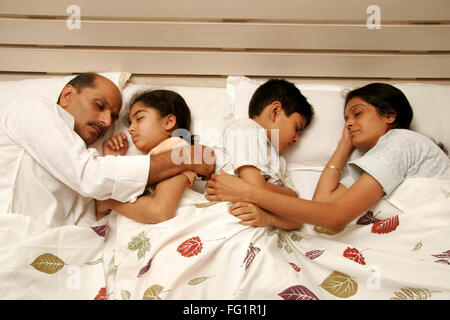 Südasiatische indischen ideale Familie kuscheln miteinander mit eingeschlafen auf Bett Herr #686E, 191, 686D, 189 Stockfoto