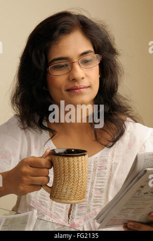 Mittelalter Frau mit Brille lesen Zeitung hält Becher 5. Juni 2010 Herr #686U Stockfoto