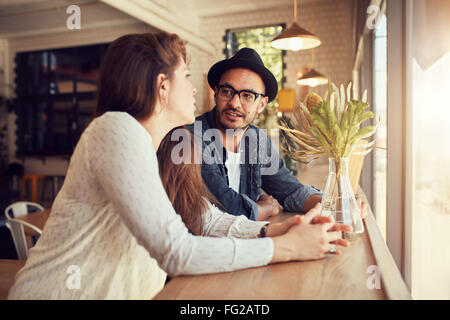 Porträt des jungen Mann und Frau in einem Café sitzen und reden. Junges Paar in einem Café entspannen. Stockfoto