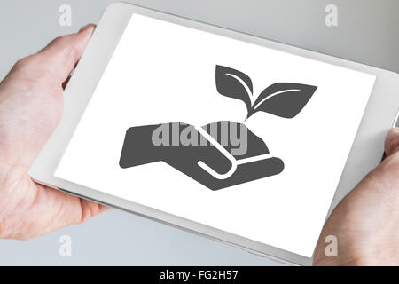 Nachhaltiges Konzept visualisiert von hand Holding wachsende Pflanze auf Touch-Screen des mobilen Tablet angezeigt. Stockfoto
