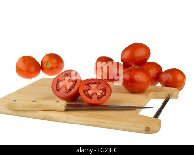 Pflanzliches; Tomaten auf Schneidebrett mit Messer auf weißem Hintergrund Stockfoto