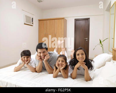 Eltern mit Kindern auf Bett im Schlafzimmer Herr #702R, Herr #702S, #702T Herr, Herr #702U Stockfoto