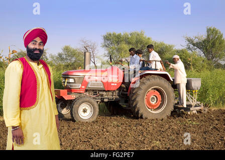 Sikh Mann mit den Landwirten mit Traktor im Feld Herr #779A Stockfoto