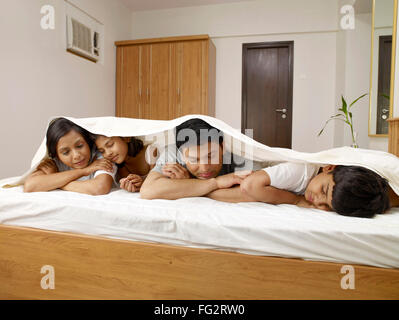 Eltern mit Kindern unter Bett Laken schlafen im Bett im Schlafzimmer Herr #702R, Herr #702S, #702T Herr, Herr #702U Stockfoto