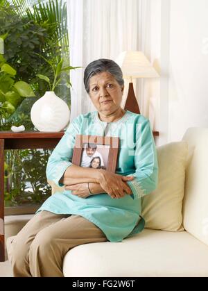 Alte Dame in traurige Stimmung halten Fotorahmen Familie Herr #702S Stockfoto