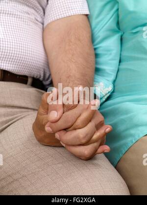 Altes Paar halten Hände sitzen dicht beieinander Herr #702T, 702S Stockfoto