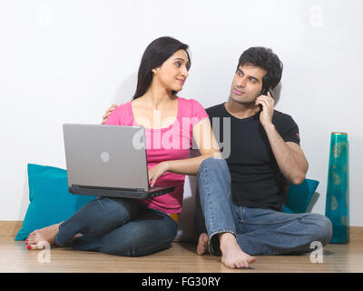 Mann am Telefon und Frauen mit Laptop sprechen; HERR #779 L; HERR #779 M Stockfoto