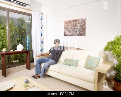 Junger Mann auf Sofa Herr #702V Stockfoto