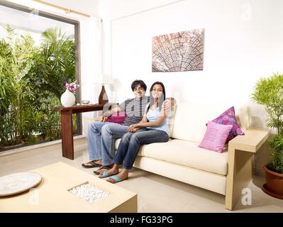 Junger Mann und Frau umarmt auf Sofa Herr #702V, 702U Stockfoto