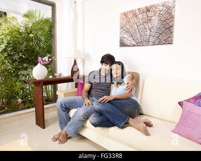 Junger Mann und Frau schloss die Augen umarmen auf Sofa Herr #702V, 702U Stockfoto