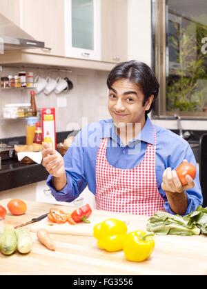 Junger Mann genommen fangen der Tomate in der hand Herr #702V Stockfoto
