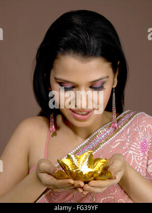 Südasiatische Indianerin lächelnd und goldene Farbe Diya einerseits Palmen Herr # 702 Stockfoto