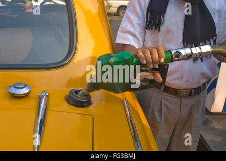 Mann in gelb Botschafter Taxi an Zapfsäule Benzin tanken; Bhowanipur; Calcutta; Westbengalen; Indien Stockfoto