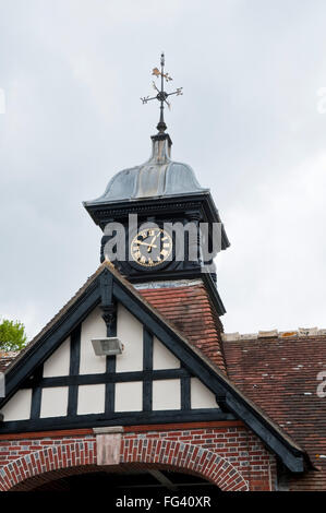 Uhr und Wetterfahne über einem der Eingänge zum Lulworth Hof, eine ehemalige Stallungen auf dem Anwesen von Lulworth, Dorset Stockfoto