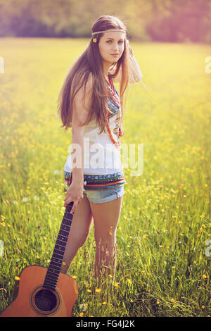 Wunderschöne Hippie-Frau mit Gitarre. Sommer-Farben-Porträt Stockfoto