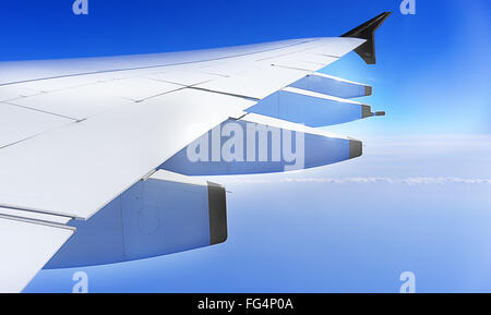 Flugzeug Flügel, Flugzeug reisen in großer Höhe mit blauem Himmel Stockfoto