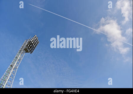 Stadion-Strahler mit Flugzeug über blauen Himmel im Hintergrund Stockfoto