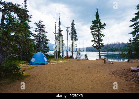 Am großen See Campingplatz in Oregon in der Nähe von Mt Washington mit einem blauen Zelt Setup in der Nähe von Wasser. Stockfoto