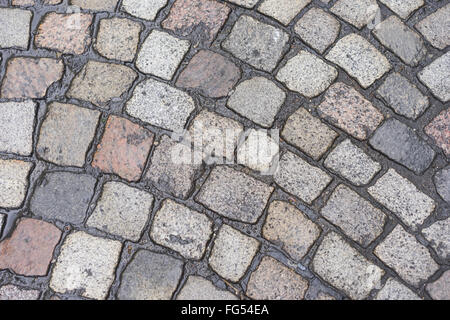 Alte nasse Fahrbahn mit Kopfsteinpflaster Textur Hintergrund Stockfoto