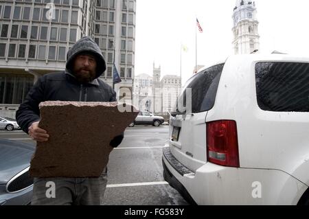 Philadelphia, Pennsylvania, USA. 13. Februar 2016. RYAN GEE, von Philadelphia, schleppt ein beträchtliches Stück aus rotem Granit fand er im LOVE Park, um den Kofferraum seines Wagens. Er will das Haus als ein Andenken zu bringen, wie er es während ein 13. Februar 2016 Treffen der Skateboarder im öffentlichen Park Center City Philadelphia, Pennsylvania, abgeholt. © Bastiaan Slabbers/ZUMA Draht/Alamy Live-Nachrichten Stockfoto