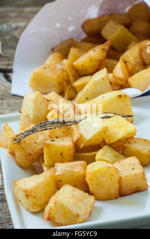 quadratische frittierte Kartoffeln auf Papier und Tablett Stockfoto