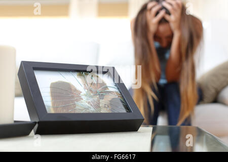 Traurig verzweifelt Frau oder Freundin nach einer Trennung in eine Couch zu Hause sitzen Stockfoto