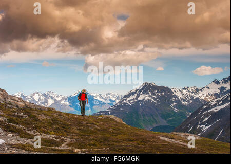 Ein Mann Wandern in der Nähe des Harding Icefield Trail mit den Chugach Mountains und dem Resurrection Valley im Hintergrund, Kenai Fjords National Park, ... Stockfoto