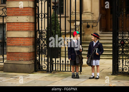 Jugendliche jungen und Mädchen in uniform sprechen außerhalb der Schule; London, England Stockfoto
