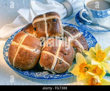 Hot Cross Buns auf Teller mit Tasse Tee in Studioumgebung Stockfoto