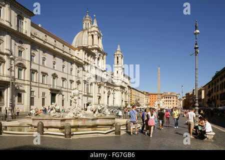 Touristen auf der Piazza Navona, Rom, Italien mit dem 17. Jahrhundert barocke Chiesa di Sant'Agnese in Agone hinter. Stockfoto