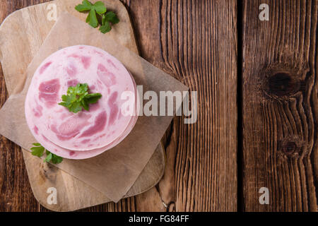 Geschnittene Schinkenwurst auf hölzernen Hintergrund (Tiefenschärfe) Stockfoto