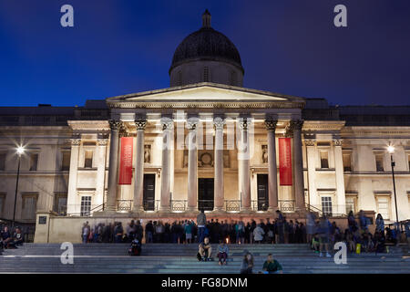 Die National Gallery am Trafalgar Square in London am Abend mit Publikum Stockfoto