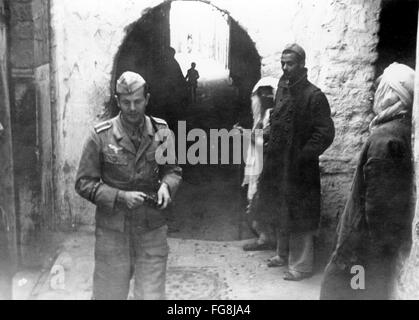 Das Nazi-Propagandafild zeigt einen deutschen Soldaten, der eine Fotokamera hält, während er die Stadt Tunis in Tunesien besucht. Das Foto wurde im Dezember 1942 aufgenommen. Fotoarchiv für Zeitgeschichtee - KEINE ÜBERWEISUNG - Stockfoto