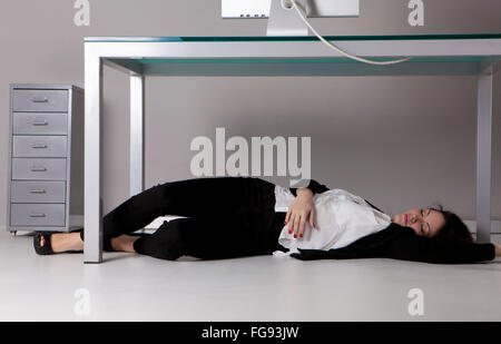 Frau liegt auf dem Boden im Büro Stockfoto