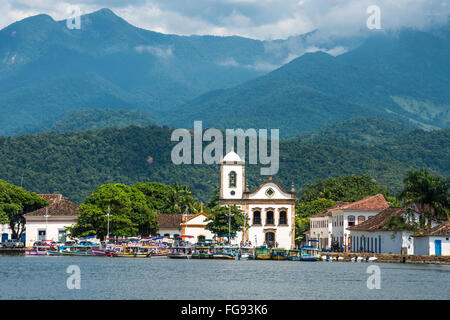 Ausflugsboote warten auf Touristen in der Nähe von der Kirche Igreja de Santa Rita de Cassia in Paraty Stockfoto