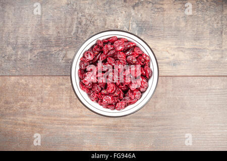 Getrocknete Cranberries in einer Schüssel auf hölzernen Hintergrund. Stockfoto