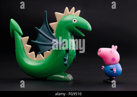 Tambow, Russische Föderation - 16. Dezember 2015 George Pig Spielzeug Charakter mit grüner Dinosaurier auf schwarzem Hintergrund. Studio gedreht. Stockfoto