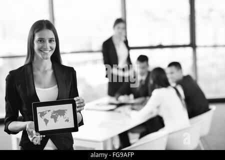 Business-Frau mit ihren Mitarbeitern im Hintergrund im Büro Stockfoto