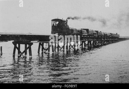 Modernisierung von Taiwan unter japanischer Herrschaft. Zug mit Zuckerrohr. Vor 1915. Xiadanshuixi River Bridge (jetzt Kaoping alten Strombrücke) Kaohsiung, Taiwan. KaohsiungThis Brücke wurde Japanisch Ingenieur Toyoji Iida. Stockfoto